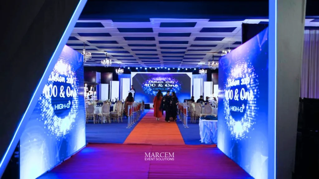 Corporate event planner managing a professional business conference with stage, lighting, and seated attendees