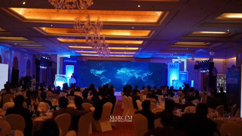 Corporate event planner managing a professional business conference with stage, lighting, and seated attendees